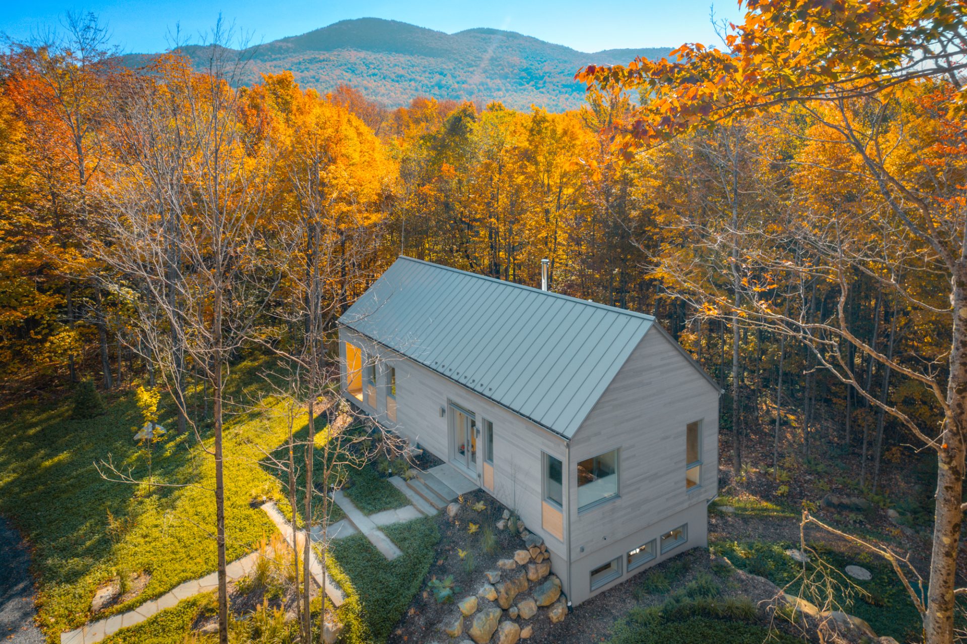 maison scandinave avec forêt et montagne, paysage d'automne